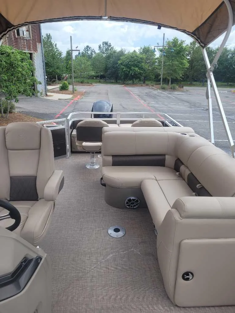 Slide: The Image of 2025 Sun Tracker SportFish 22 DLX boat interior with beige seating and storage compartments. - 6