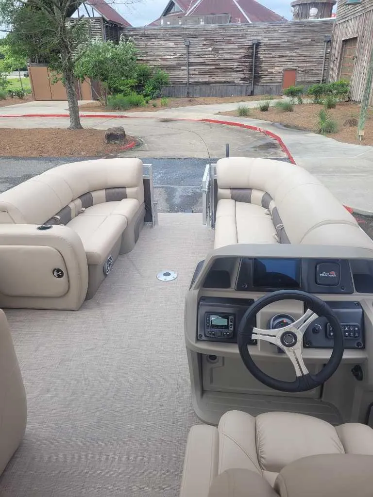 Slide: The Image of 2025 Sun Tracker SportFish 22 DLX interior storage compartment with beige seating. - 7