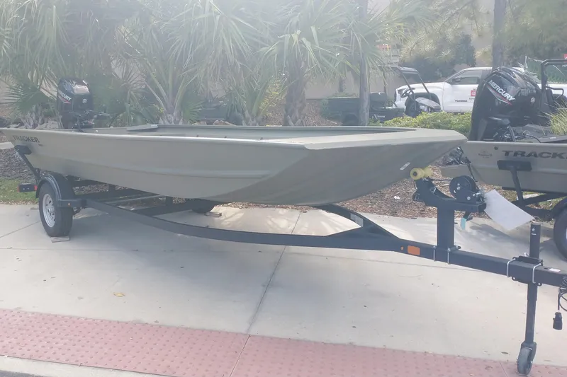 Slide: The Image of 2025 Tracker Grizzly 1860 Utility boat on trailer, parked outdoors. - 2