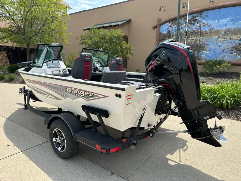 Slide: The Image of 2025 Ranger VS1682SC Reata boat with outboard motor on a trailer, parked outdoors. - 2