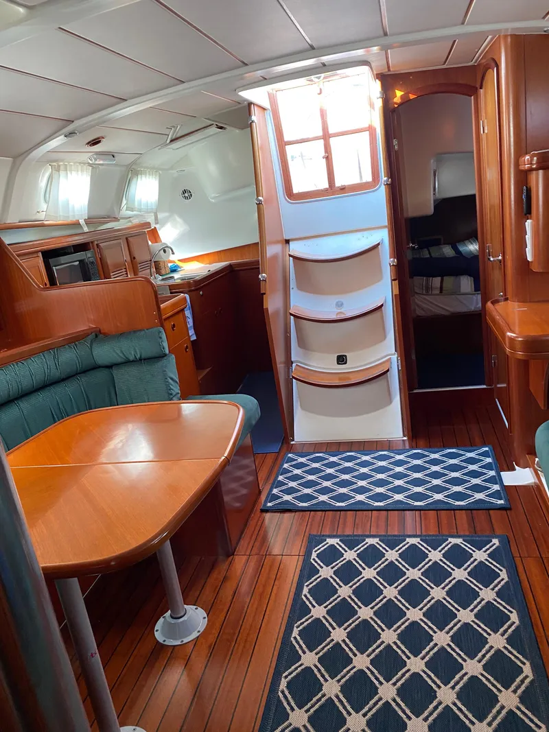 Slide: The Image of Interior of 2001 Beneteau 411 sailboat with wood finish and cozy seating area. - 10