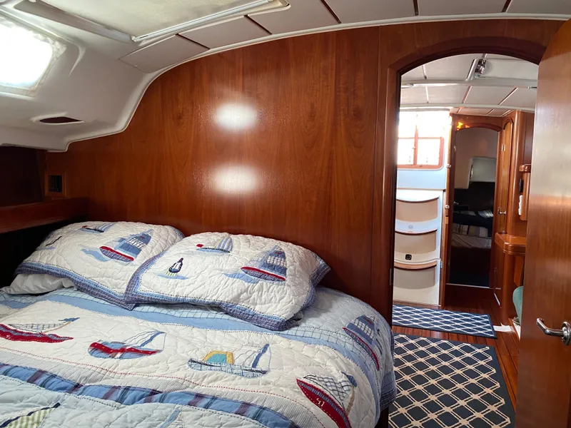 Slide: The Image of Cozy cabin interior of 2001 Beneteau 411 sailboat with nautical-themed bedding. - 11