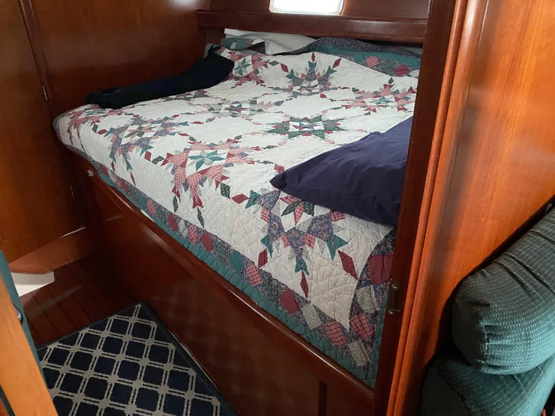 Slide: The Image of Cozy cabin interior of 2001 Beneteau 411 sailboat with patterned quilted bedspread. - 12