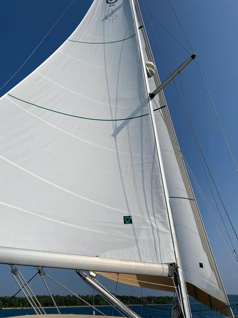 Slide: The Image of Sailing yacht Beneteau 411, 2001 model, with white sails against a clear blue sky. - 13