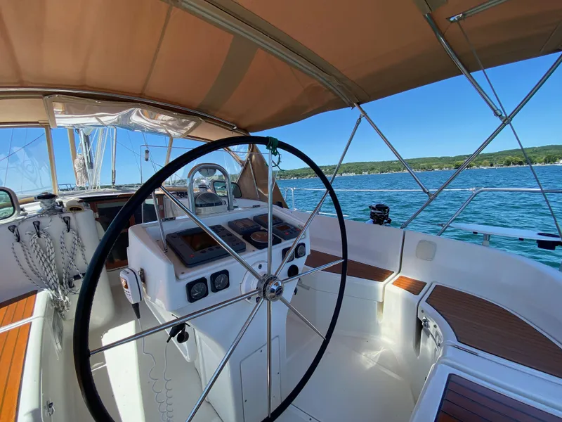 Slide: The Image of Cockpit of 2001 Beneteau 411 sailboat with steering wheel, overlooking serene blue waters. - 4