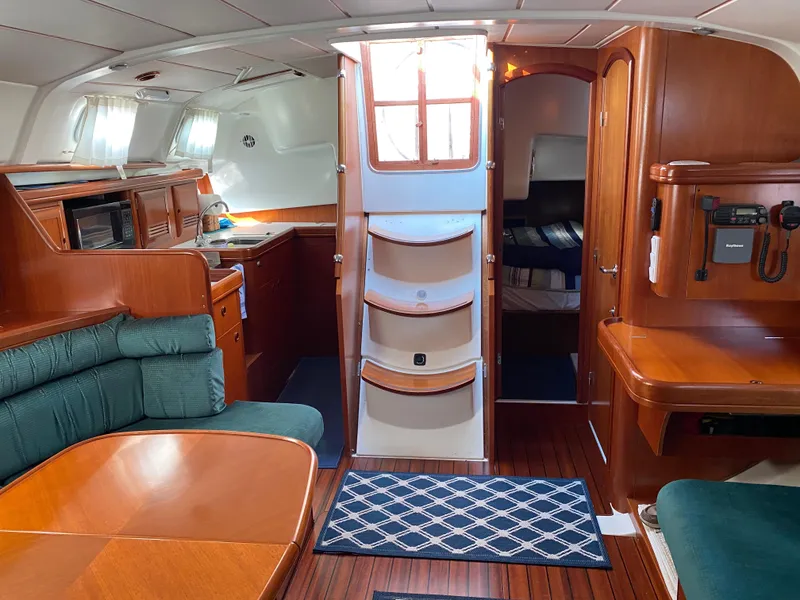 Slide: The Image of Interior of 2001 Beneteau 411 sailboat with wood finish and cozy seating area. - 7