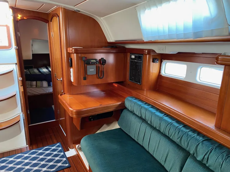 Slide: The Image of Interior of 2001 Beneteau 411 sailboat with wooden cabinetry and green seating. - 8