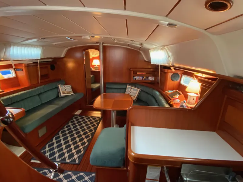Slide: The Image of Interior of 2001 Beneteau 411 sailboat with cozy seating and wooden finishes. - 9