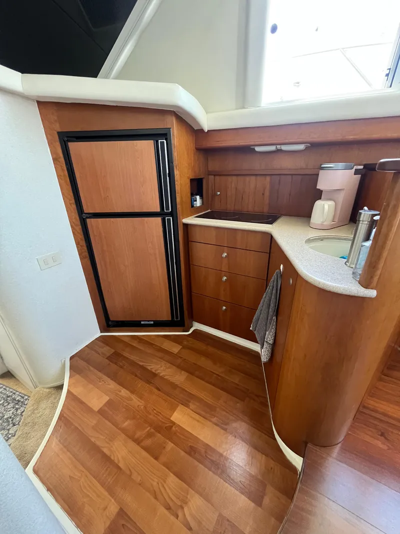 Slide: The Image of 1996 Silverton 362 Sedan Cruiser kitchen with wood cabinetry and compact appliances. - 31
