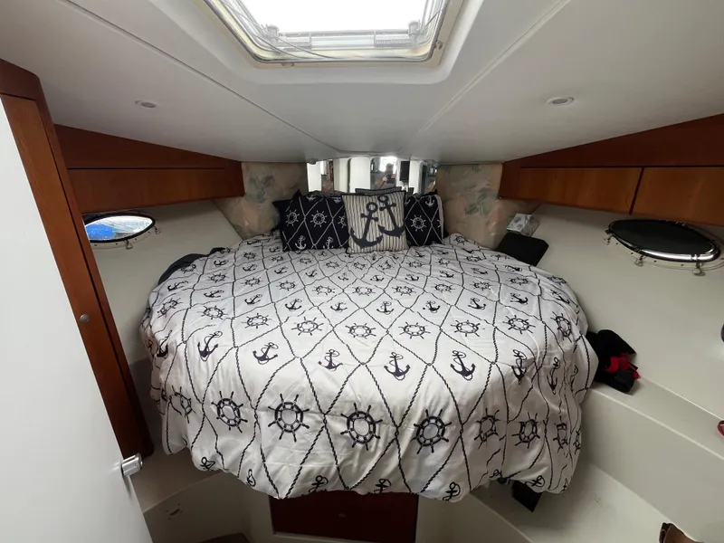 Slide: The Image of Cozy cabin interior of 1996 Silverton 362 Sedan Cruiser with nautical-themed bedding. - 38