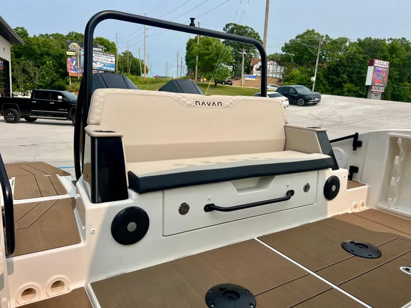 Slide: The Image of 2025 Navan S-30 boat interior with beige seating and black accents, parked outdoors. - 10