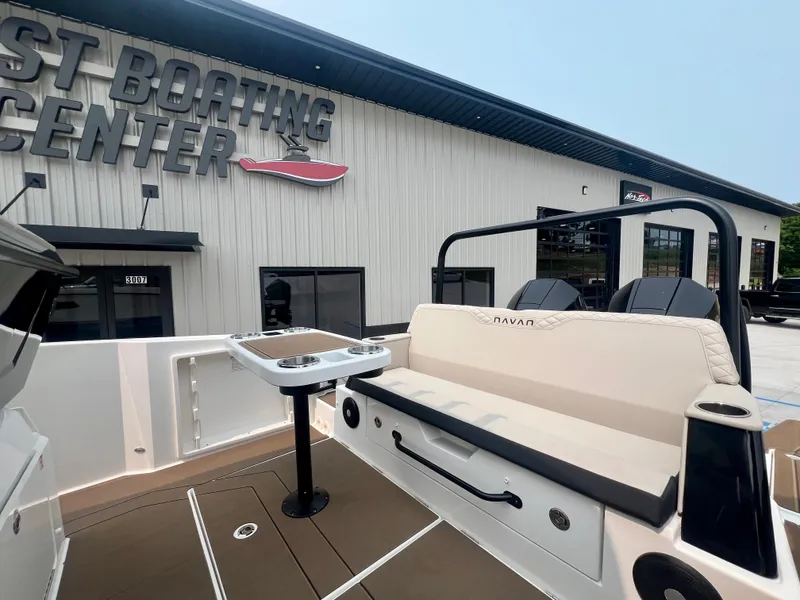 Slide: The Image of 2025 Navan S-30 boat at dealership, featuring seating and table, outside a boating center. - 12