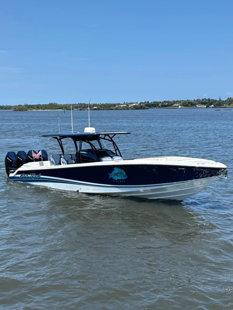 The Image of 2024 Nor-Tech 390 Sport Center Console boat on calm water, featuring sleek design and powerful engines. - 1