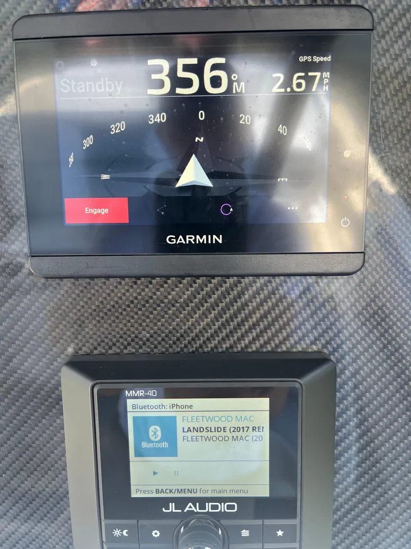 Slide: The Image of Garmin and JL Audio displays on 2024 Nor-Tech 390 Sport Center Console boat dashboard. - 10