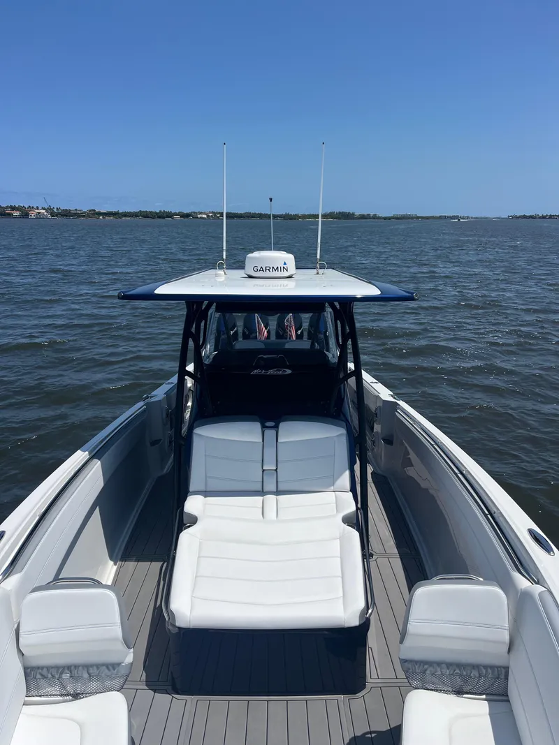 Slide: The Image of 2024 Nor-Tech 390 Sport Center Console boat on open water, featuring sleek design and spacious seating. - 12
