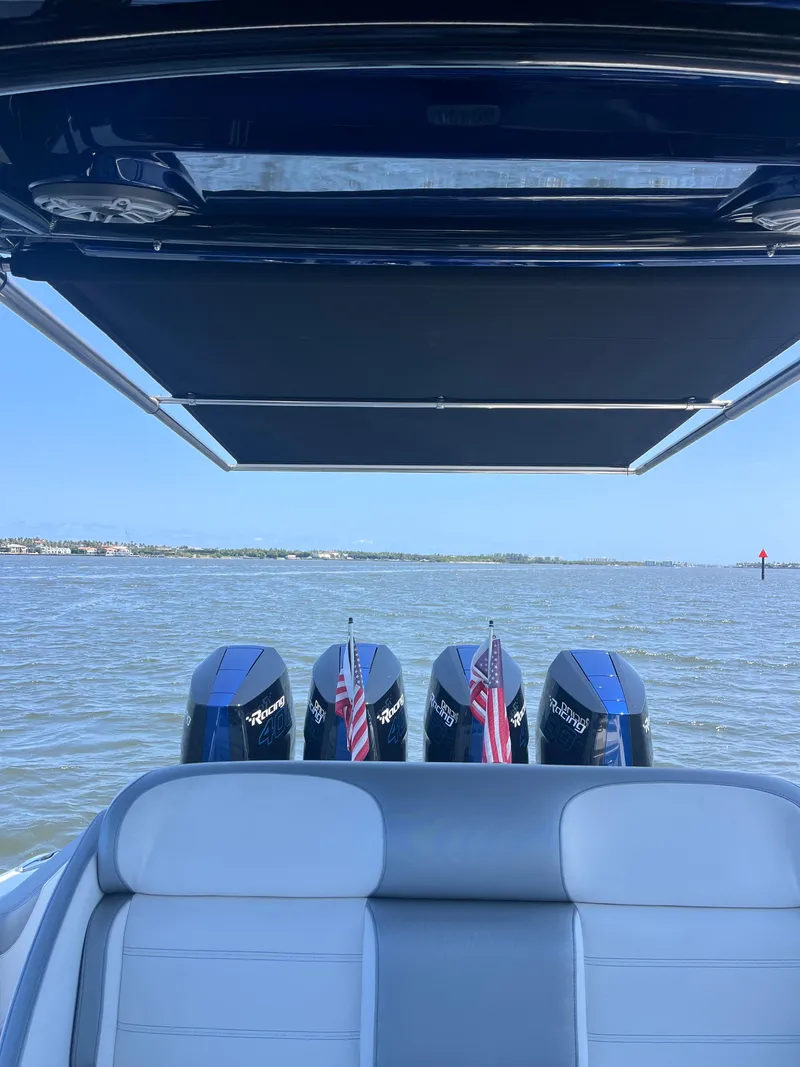 Slide: The Image of 2024 Nor-Tech 390 Sport Center Console on water, featuring triple engines and sunshade. - 5