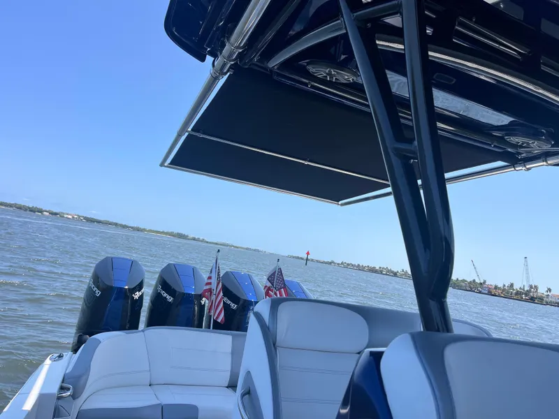 Slide: The Image of 2024 Nor-Tech 390 Sport Center Console boat with multiple engines on open water. - 6