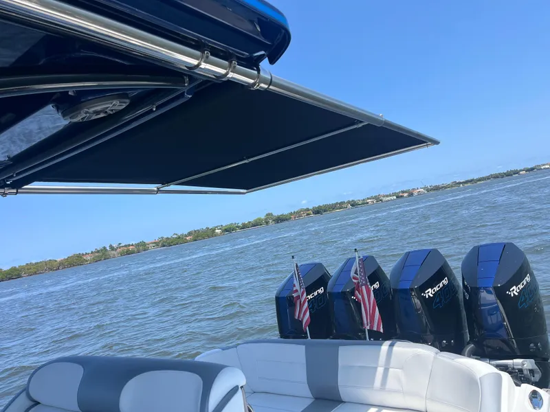 Slide: The Image of 2024 Nor-Tech 390 Sport Center Console boat with multiple outboard engines on a sunny day. - 7