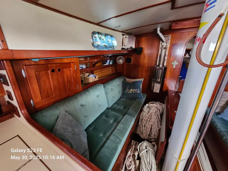 Slide: The Image of Cozy interior of 1989 Valiant 40 Cutter with green sofa and wooden cabinetry. - 10