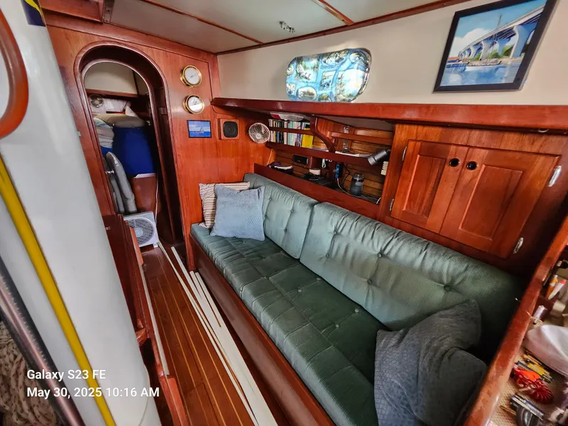 Slide: The Image of Cozy interior of 1989 Valiant 40 Cutter sailboat with wooden furnishings and green sofa. - 11