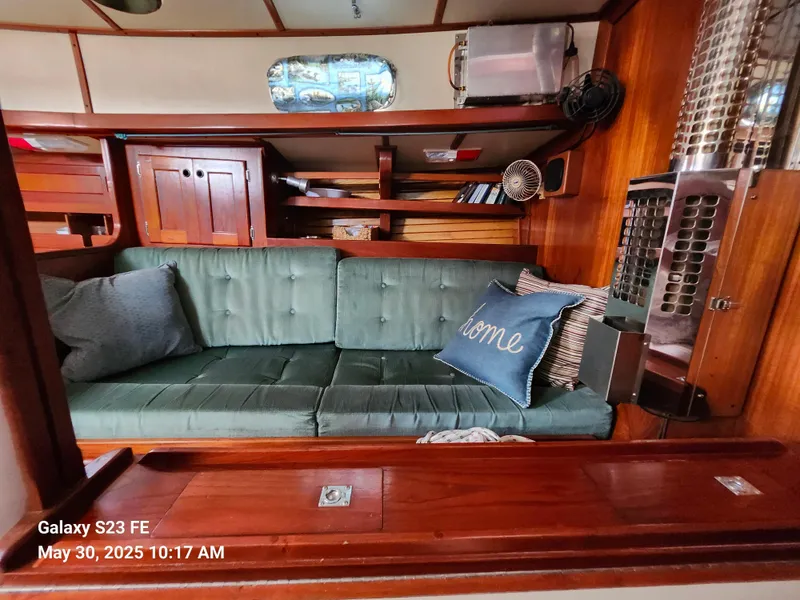 Slide: The Image of Cozy interior of 1989 Valiant 40 Cutter with green sofa and wooden cabinetry. - 12