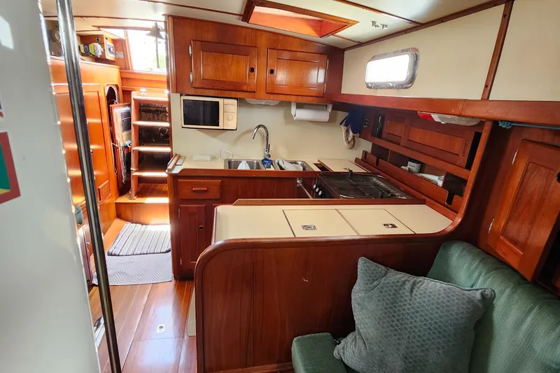 Slide: The Image of 1989 Valiant 40 Cutter interior with wooden cabinetry and compact kitchen area. - 14