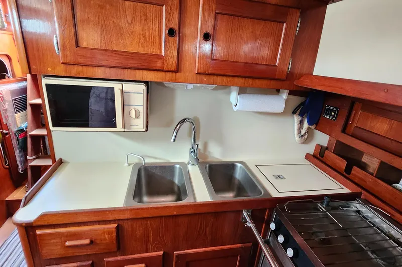 Slide: The Image of Galley kitchen in 1989 Valiant 40 Cutter with wood cabinetry and dual sinks. - 18