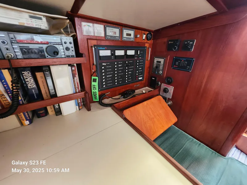 Slide: The Image of 1989 Valiant 40 Cutter interior with navigation panel, radio, and bookshelf. - 22