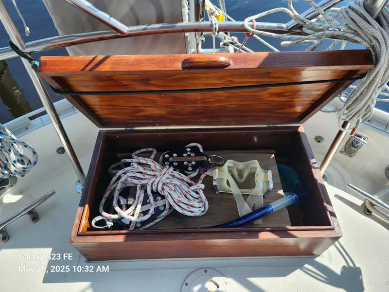 Slide: The Image of Open wooden storage box on 1989 Valiant 40 Cutter sailboat deck with ropes and tools. - 30