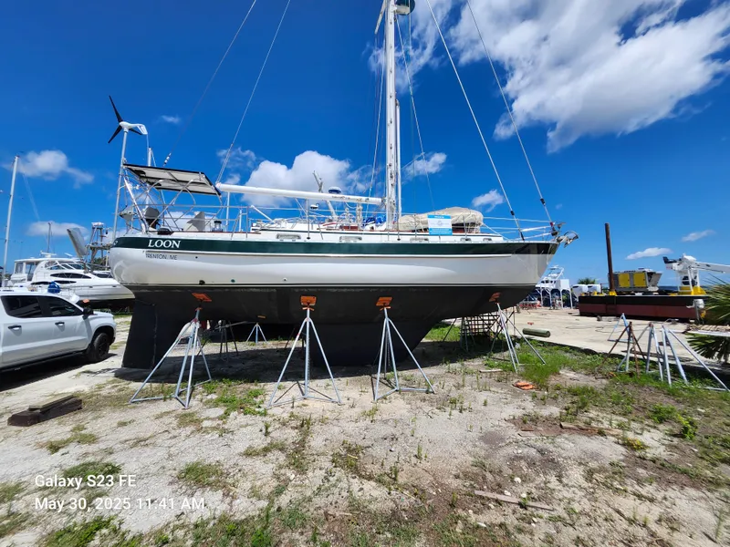 Slide: The Image of 1989 Valiant 40 Cutter sailboat on stands in a boatyard under a clear blue sky. - 4