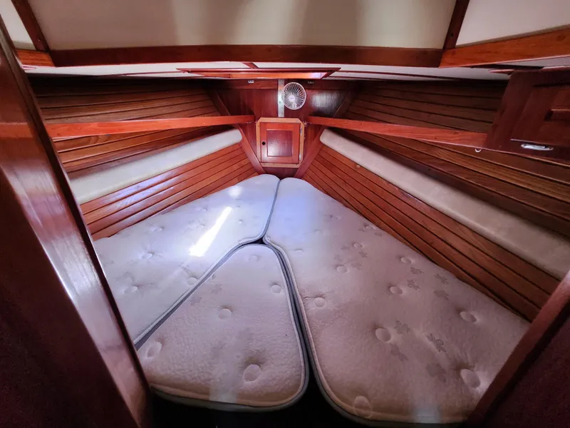 Slide: The Image of Cozy cabin interior of 1989 Valiant 40 Cutter with wooden paneling and cushioned bedding. - 50