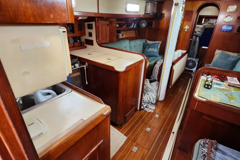 Slide: The Image of Interior of 1989 Valiant 40 Cutter sailboat with wooden cabinetry and cozy seating area. - 9