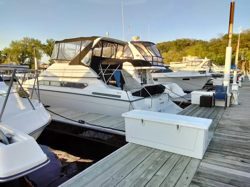 Slide: The Image of 1994 Carver 380 Santego yacht docked at a marina, surrounded by other boats. - 11