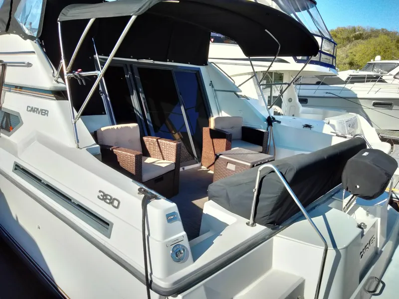 Slide: The Image of 1994 Carver 380 Santego yacht with outdoor seating, docked at a marina. - 6