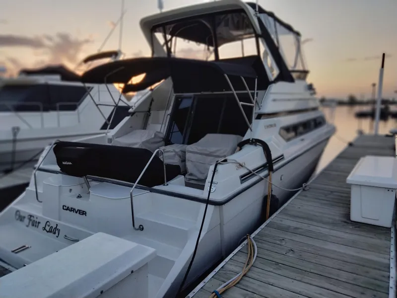 Slide: The Image of 1994 Carver 380 Santego yacht docked at sunset, featuring sleek design and spacious deck. - 8