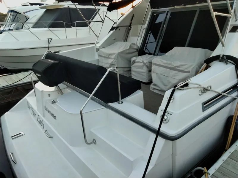 Slide: The Image of 1994 Carver 380 Santego yacht docked, featuring covered seating and sleek design. - 9