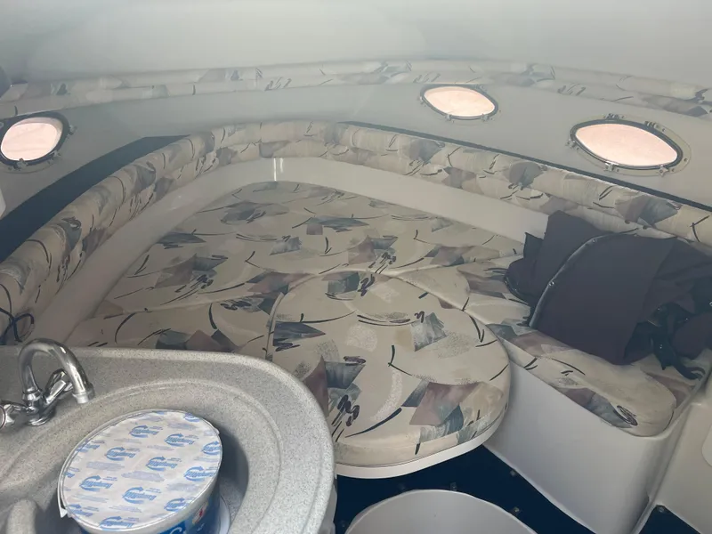 Slide: The Image of Interior of 1997 Chris-Craft 26 Crowne Cruiser with patterned seating and small sink. - 11