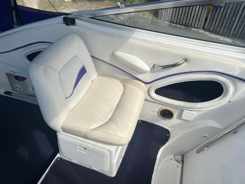 Slide: The Image of 1997 Chris-Craft 26 Crowne Cruiser interior with white seating and blue accents. - 7