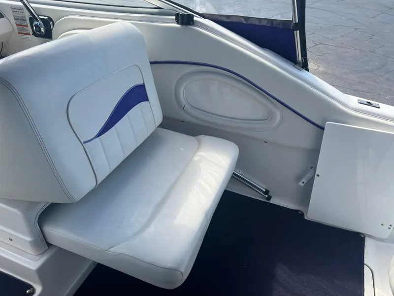 Slide: The Image of 1997 Chris-Craft 26 Crowne Cruiser interior with white seating and blue accents. - 9