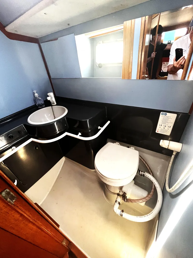 Slide: The Image of Bathroom interior of 1990 Jeanneau Sun Magic 44 yacht, featuring sink and toilet. - 14