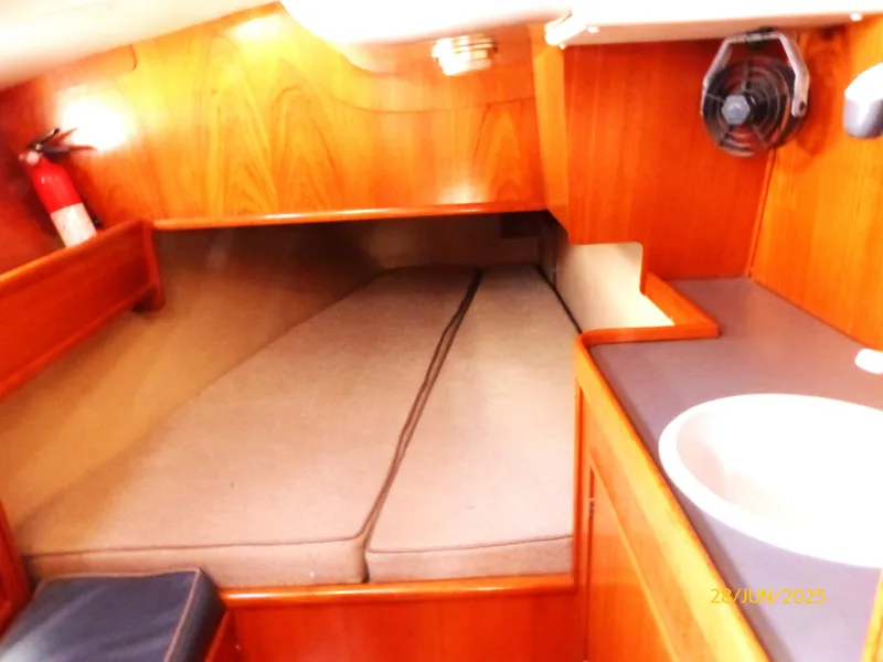 Slide: The Image of Cozy cabin interior of 1990 Jeanneau Sun Magic 44 sailboat with wooden finish and compact bed. - 15