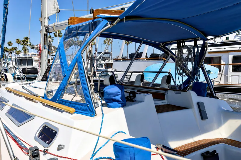 Slide: The Image of Jeanneau Sun Magic 44 sailboat, 1990 model, featuring blue canopy and deck details at marina. - 19
