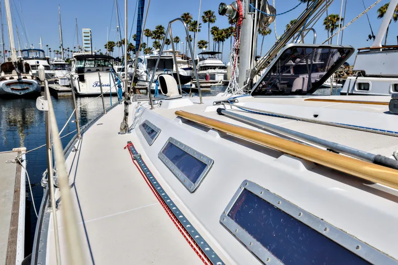 Slide: The Image of 1990 Jeanneau Sun Magic 44 sailboat docked in a marina with palm trees. - 25