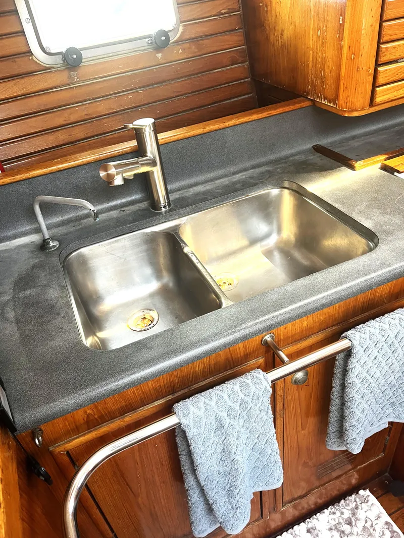 Slide: The Image of Double sink in Jeanneau Sun Magic 44 yacht kitchen, 1990 model, with wooden cabinetry. - 4