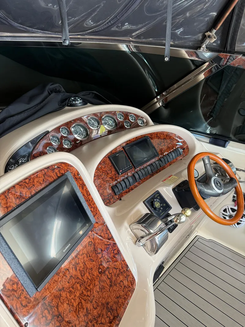 Slide: The Image of 2002 Sea Ray 410 Sundancer helm with wood accents and modern navigation equipment. - 10