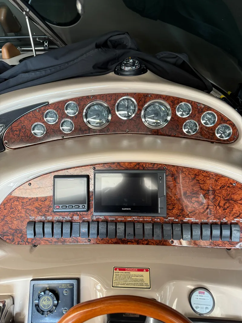 Slide: The Image of Dashboard of a 2002 Sea Ray 410 Sundancer with gauges and navigation equipment. - 11