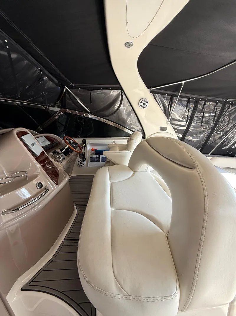 Slide: The Image of Interior of a 2002 Sea Ray 410 Sundancer yacht with white seating and sleek dashboard. - 12