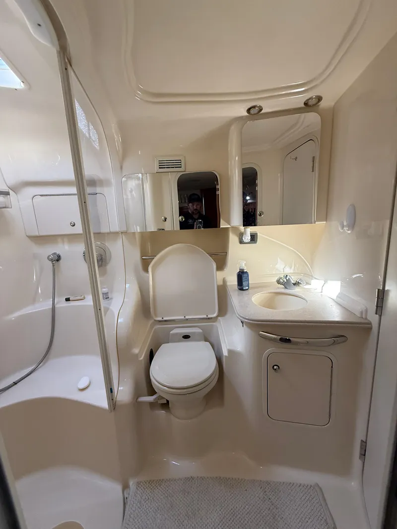 Slide: The Image of 2002 Sea Ray 410 Sundancer bathroom with shower, toilet, and sink in compact layout. - 13