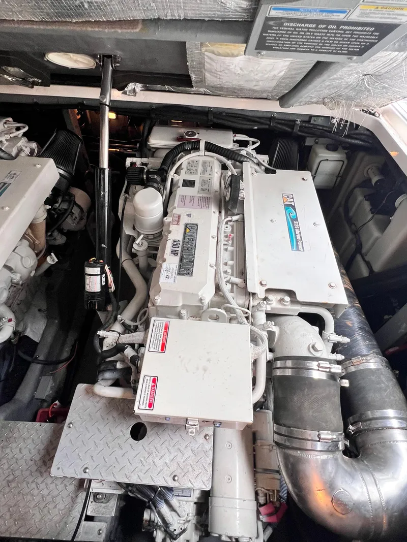Slide: The Image of Engine compartment of a 2002 Sea Ray 410 Sundancer boat, showcasing detailed machinery. - 14
