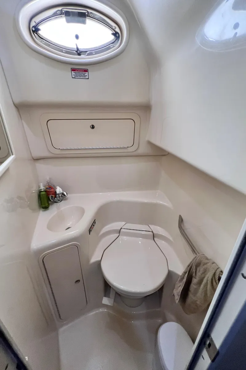Slide: The Image of Compact bathroom in 2002 Sea Ray 410 Sundancer yacht with sink, toilet, and porthole window. - 24